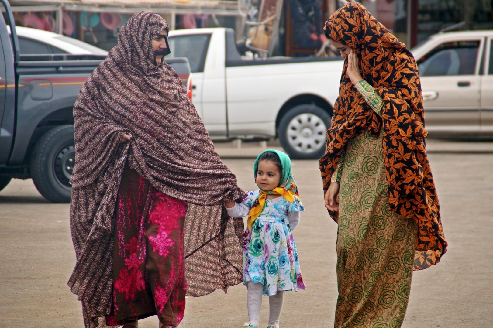 Colourful women and girl in Qeshm - notice the women in pink/purple wearing the traditional mask